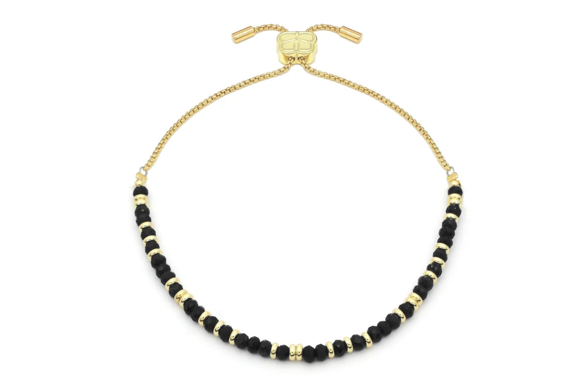Introducing the BR: Mystical Black Spinel Gold bracelet from Benet Store, Inc.—an adjustable gold chain adorned with alternating small black spinel and gold beads, beautifully showcased on a white background. This elegant piece is perfect for adding a mystical touch of jewelry to any ensemble.