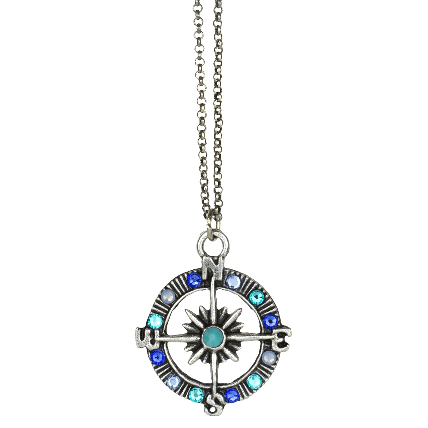 The Whimsy Fancy Blue Compass Necklace by Anne Koplik Designs, Inc. features a silver compass pendant with blue and turquoise gemstones, cardinal direction letters, a starburst center, and hangs from a silver chain.