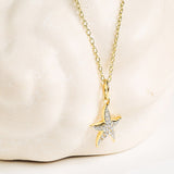 The Shanore Gold Vermeil & White Sapphire Starfish Mini Necklace features a shimmering starfish pendant, shown against a marble-inspired background.