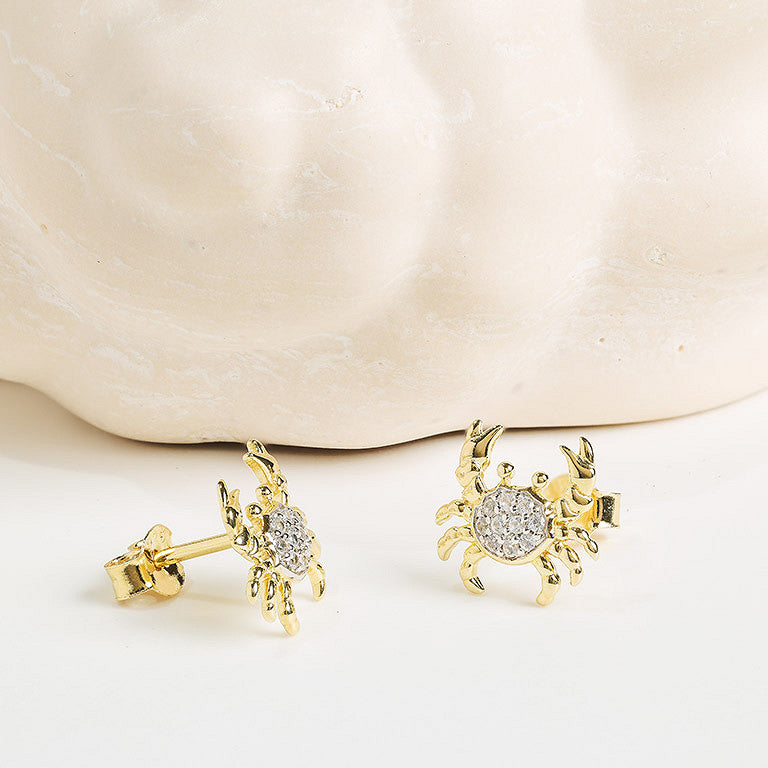 Shanore Gold Vermeil & White Sapphire Crab Post Earrings are shown on a light, textured surface.