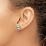 Close-up of a womans ear wearing Presco/Quality Gold Crystal Aqua Sun Post Earrings, featuring a blue gemstone center and a decorative sunburst design in sterling silver.