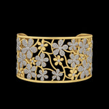 The Be-Je Designs Gold Pave CZ Flower Cutouts Cuff Bracelet showcases sparkling cubic zirconia flowers and leaves in an openwork design, set against black for a touch of everyday luxury.