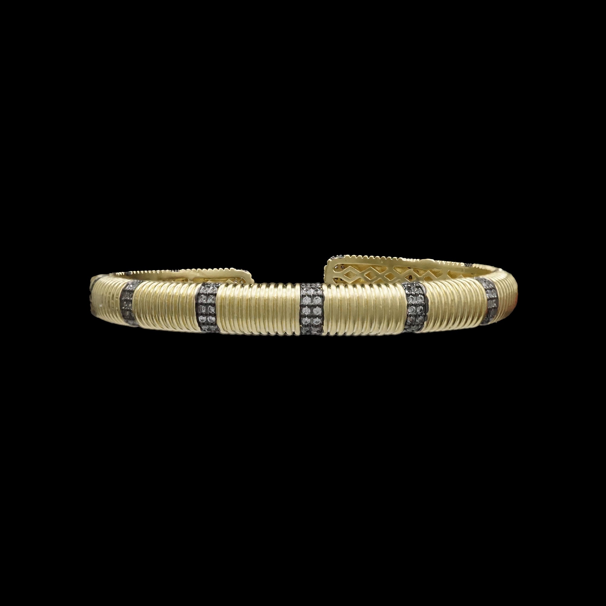 The Be-Je Designs Black/Gold Hinged Cuff w/ Gold and Pave Lines Bracelet features gold ribs and silver diamond pave lines, displayed against a black background.