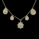 The Be-Je Designs Gold Charms Evil Eye Necklace features five 14kt gold charms—an eye, crescent moon with stars, sunburst, and two teardrops—set against black with sparkling cubic zirconia for a bold look.