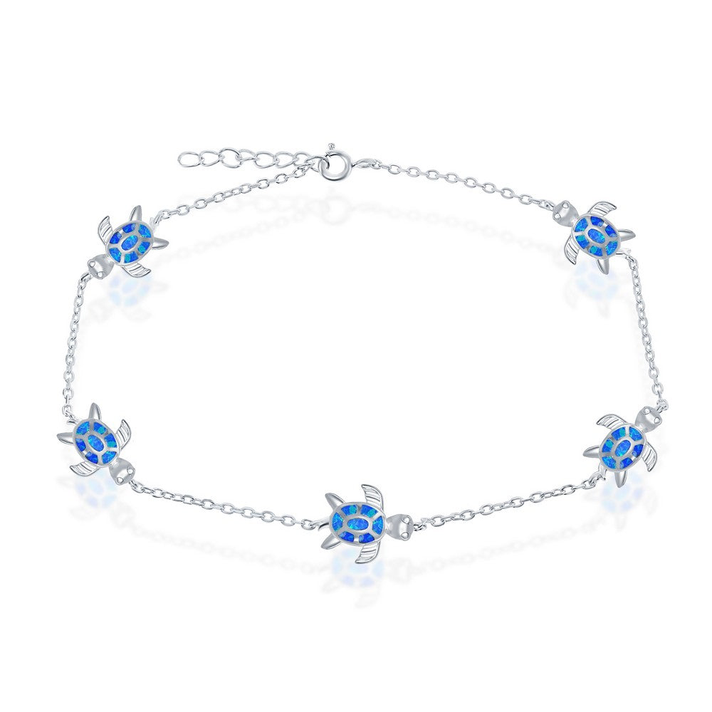 The Caribbean Opal Inlay Turtle Anklet by Classic of New York features five blue sea turtle charms with detailed flippers and patterned shells—a stylish sterling silver accessory perfect for beach lovers.