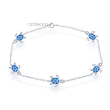 The Caribbean Opal Inlay Turtle Anklet by Classic of New York features five blue sea turtle charms with detailed flippers and patterned shells—a stylish sterling silver accessory perfect for beach lovers.