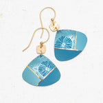 The Rowan Sky Blue Earrings by Holly Yashi feature gold hooks, geometric blue pendants, and hypoallergenic materials. Their abstract light blue, teal, and gold accents are highlighted with delicate white floral designs.