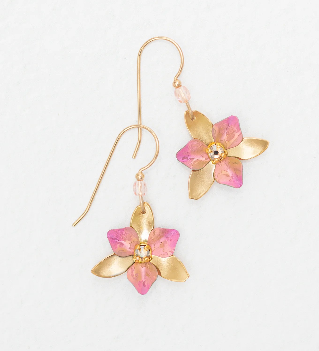 The Special Edition Orla Drops Earrings by Holly Yashi feature gold flower-shaped hooks with pink accents and sparkling Austrian crystals at the center, shown on a plain white background.