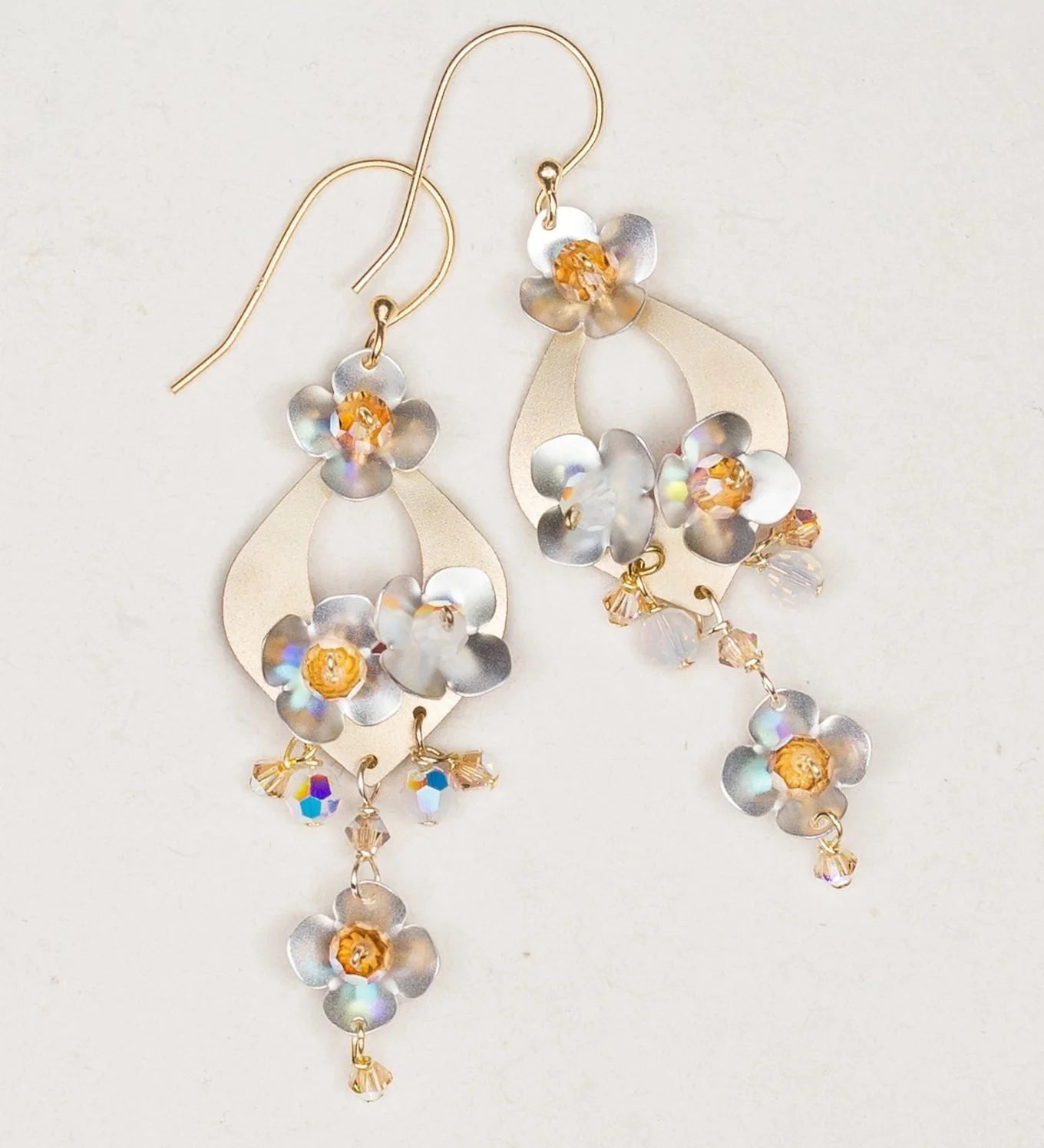 Holly Yashi’s Hawaiian Wedding Gold/Silver Earrings feature gold hooks, metallic floral shapes, iridescent beads, and shimmering flower accents—perfect for a gorgeous wedding look.