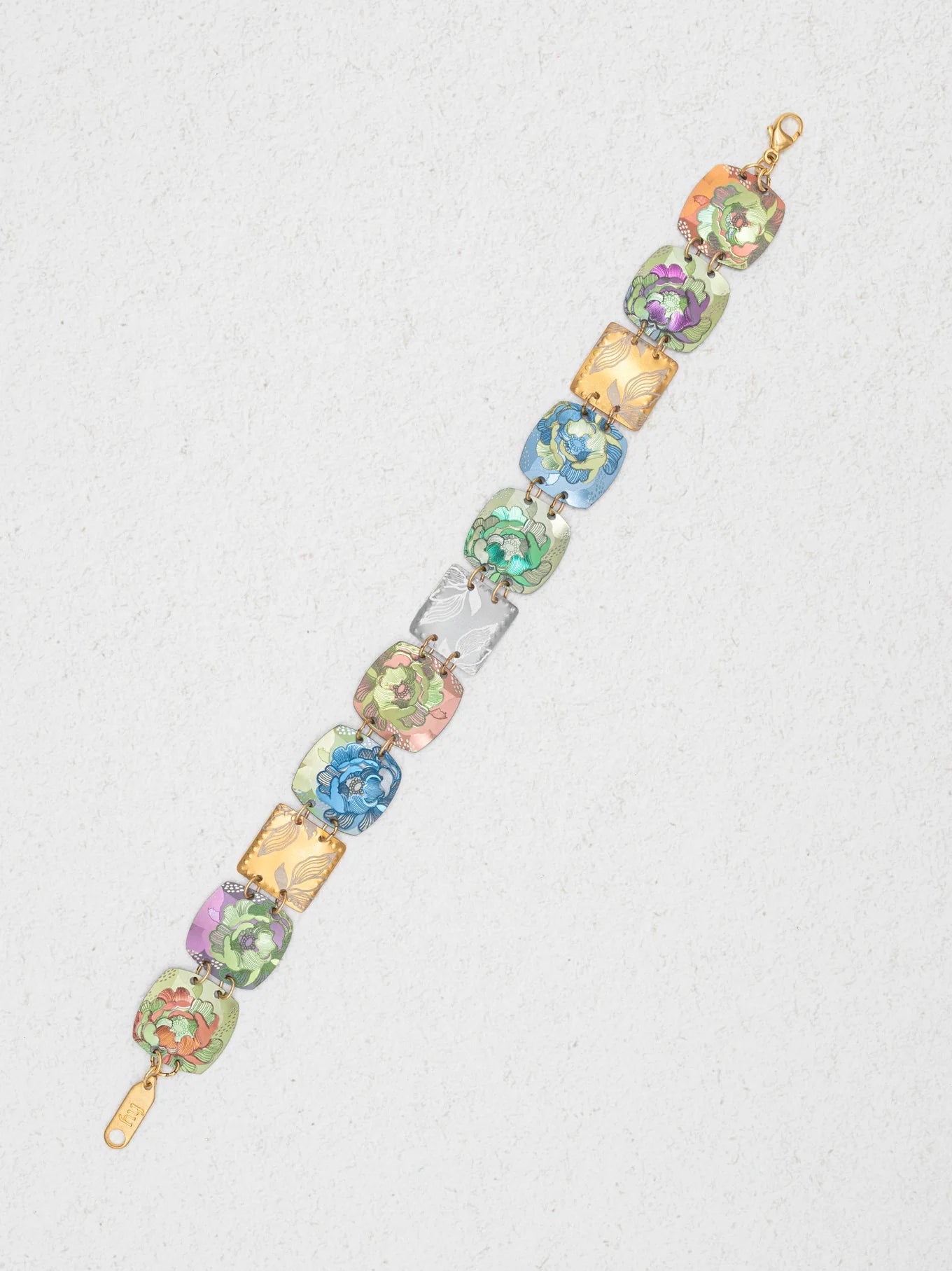 The Flora Multi Color Earrings by Holly Yashi feature vibrant green, blue, pink, yellow, and purple floral designs on gold-tone links—a striking piece of niobium jewelry displayed on a light textured background.