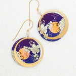 Luna Earrings/Blue Moon by Holly Yashi: Circular earrings with gold hooks, featuring a gold crescent moon over deep blue with white floral designs and an orange accent. Hypo-allergenic niobium—safe for sensitive ears.