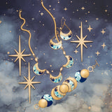 Jewelry displayed on a starry midnight blue background features the Holly Yashi Selena Midnight Blue Bracelet and matching earrings with blue, white, and gold crescent moons, accented by four gold star-shaped ornaments.