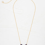 The Blooming Butterfly Blue Radiance Necklace by Holly Yashi features a gold adjustable chain and an iridescent niobium butterfly pendant with gold and turquoise accents, shown on a white textured background—a vibrant statement piece.