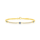 The Gold Plated CZ Evil Eye Tennis Bracelet by Classic of New York features a central blue gemstone, clear and blue accent stones, and a slim, elegant band with a clasp closure.
