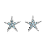 The Swarovski Crystals Aqua Starfish Stud Earrings by Shanore feature elegant five-pointed stars adorned with small round blue crystals and a silver-toned finish, capturing the sparkling allure of shimmering waters.