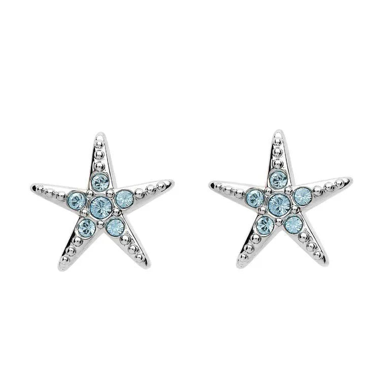 The Swarovski Crystals Aqua Starfish Stud Earrings by Shanore feature elegant five-pointed stars adorned with small round blue crystals and a silver-toned finish, capturing the sparkling allure of shimmering waters.