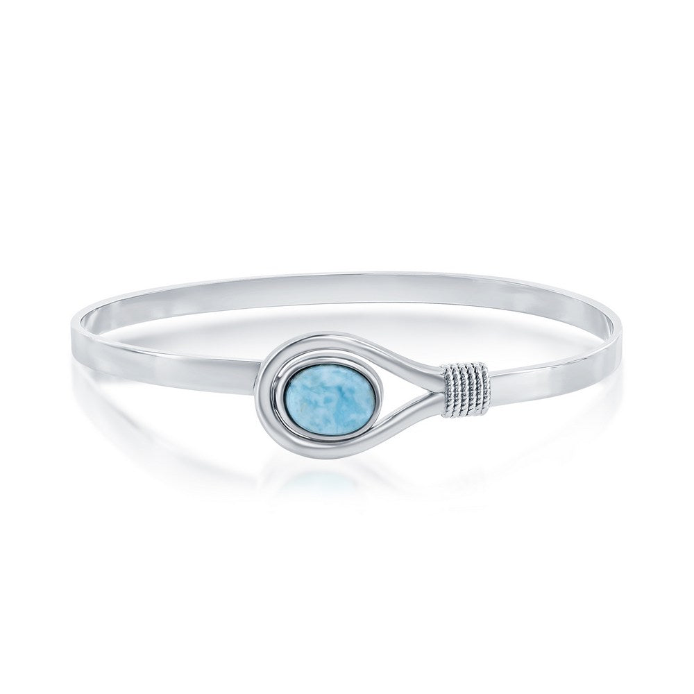 The Classic of New York Larimar Oval Bangle Bracelet features a sterling silver design with an oval blue Larimar stone at the center and elegant decorative metal wraps beside the stone.
