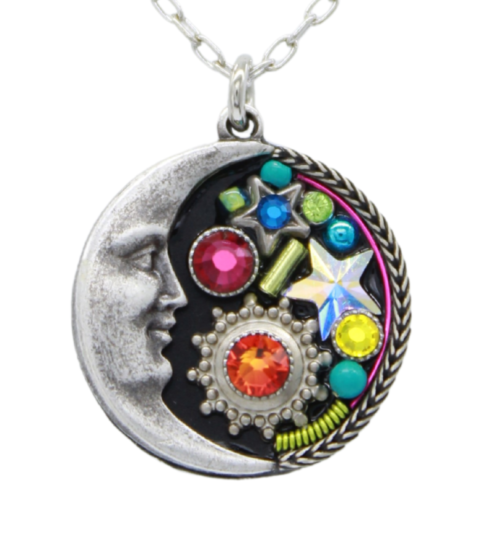 Introducing the Midnight Moon Multi-Color Necklace by Firefly Jewelry. Handmade in Guatemala, this exquisite piece features a silver crescent moon with a face on the left, vibrant gemstones, including a star and red gem, set on a black background with a rope-like border.