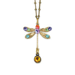 The Stone Dragonfly w/Drop Necklace by Anne Koplik Designs, Inc. features a gold dragonfly pendant with red, purple, green, and blue gemstones on antiqued brass and a round amber drop.