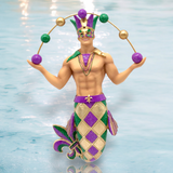 The Big Easy Ornament by December Diamonds features a festive male Mardi Gras merman adorned in a jester hat, mask, and beads. He wears a purple, gold, and green diamond-patterned tail and expertly balances gold and purple balls against a light blue background.