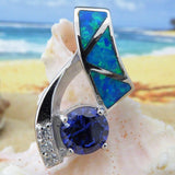 The Jewelry Network Caribbean Opal 3 Triangles/Round Amethyst pendant (pendant only) is displayed on a seashell, with turquoise geometric inlays and a round amethyst against a blurred beach and ocean background.