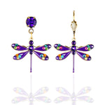 Anne Koplik Designs, Inc. Enamel/Stone Dragonfly Purple Earrings feature hand-enameled purple bodies and wings with colorful crystals; one has a hook clasp, the other a stud with a purple gem. Displayed on white with faint reflection.