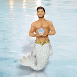 The October Birthstone-Opal Merman by December Diamonds features a light-skinned merman with brown hair and a shiny white tail, standing in blue water and holding a pastel transgender pride egg—an ideal hand-painted ornament.