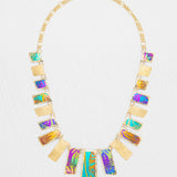 Introducing the Mahana Multi 19 Rectangular Drops Necklace by Holly Yashi: a stunning gold niobium necklace featuring alternating rectangular pendants with textured gold and colorful iridescent patterns, arranged in a symmetrical design. This unique piece of tropical jewelry effortlessly captures vibrant elegance and island-inspired style.