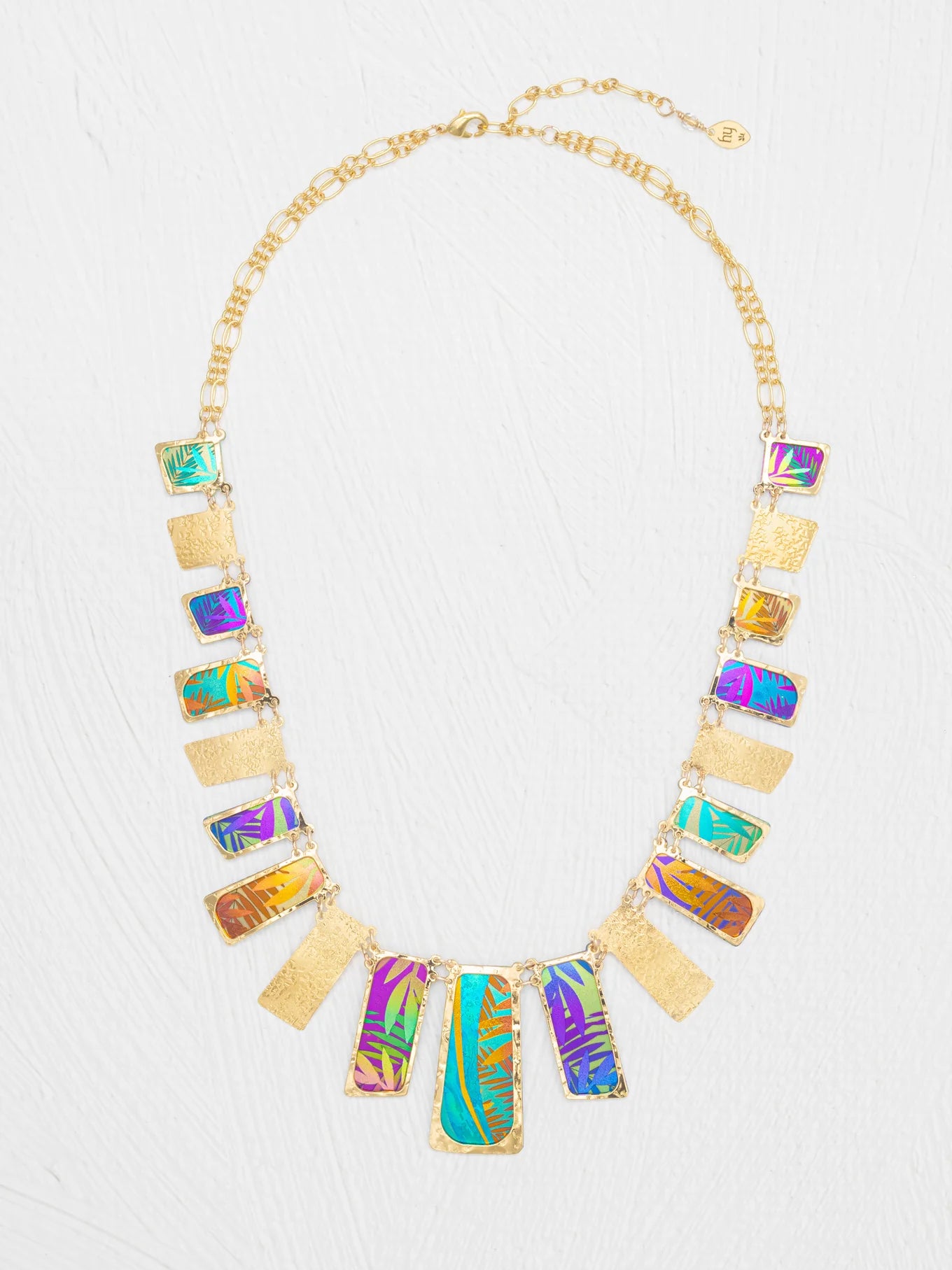 Introducing the Mahana Multi 19 Rectangular Drops Necklace by Holly Yashi: a stunning gold niobium necklace featuring alternating rectangular pendants with textured gold and colorful iridescent patterns, arranged in a symmetrical design. This unique piece of tropical jewelry effortlessly captures vibrant elegance and island-inspired style.