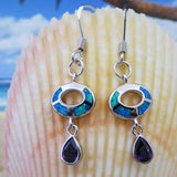 Jewelry Network's Caribbean Opal Oval w/Amethyst Teardrop Dangle Earrings are shown before a large seashell, with a beach scene in the background.