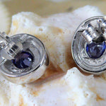 Close-up of Jewelry Network’s Caribbean Opal 4 Segments/Oval Amethyst CZ Post Earrings, featuring oval amethyst cubic zirconia stones, displayed against a textured white and beige shell background.