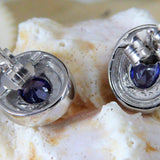 Close-up of Jewelry Network’s Caribbean Opal 4 Segments/Oval Amethyst CZ Post Earrings, featuring oval amethyst cubic zirconia stones, displayed against a textured white and beige shell background.