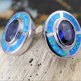 Close-up of Jewelry Network’s Caribbean Opal 4 Segments/Oval Amethyst CZ Post Earrings, featuring oval amethyst cz centers bordered by bright blue-green opal inlay, shown on a light stone background.