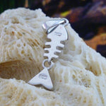 The Caribbean Opal Fish Bones-Pendant ONLY by Jewelry Network sits on a textured cream coral rock, its sterling silver marked 925, with a blurred dark background.