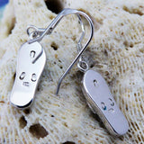 The Caribbean Opal Flip Flop Dangle Earrings by Jewelry Network feature 925 sterling silver with engraved straps and toe details, shown against a textured, cream-colored coral background.