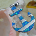 The Jewelry Network Caribbean Opal Anchor w/ Segments-Pendant ONLY is crafted from 925 sterling silver with blue opal inlays, shown resting against a pale seashell with a blurred yellow object in the background.