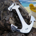 The Jewelry Network Caribbean Opal Anchor-Pendant ONLY, crafted in 925 Sterling Silver, is displayed on textured driftwood with a blurred beach and yellow boat in the background.
