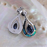 Jewelry Network’s Caribbean Opal 4 Segment Teardrop/Tanzanite CZ Post Earrings feature blue gemstone centers and green-blue accents, shown on a lustrous pearlescent shell background.