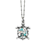 The Multi Stone Turtle Turquoise Necklace by Anne Koplik Designs, Inc. features a sterling silver turtle pendant with blue and clear gemstone accents on a beaded chain, evoking the style of classic turquoise jewelry.