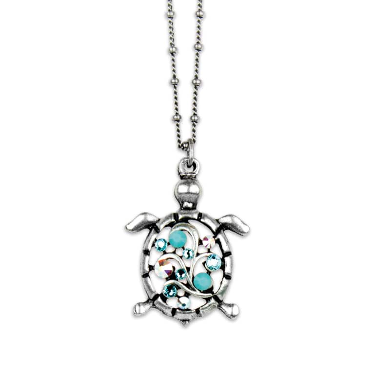 The Multi Stone Turtle Turquoise Necklace by Anne Koplik Designs, Inc. features a sterling silver turtle pendant with blue and clear gemstone accents on a beaded chain, evoking the style of classic turquoise jewelry.