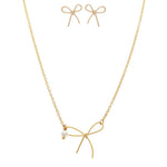 The A-Train Gold Tiny Bow with Pearl Necklace Set features a delicate bow pendant and matching gold bow stud earrings, beautifully presented on a white background.