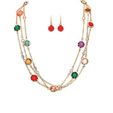 Introducing the A-Train Gold Multicolor Jewel Gems Layer Chain Necklace Set, featuring three elegant gold layered chains adorned with vibrant multicolor jewel gem accents. This stunning set is paired with matching red gemstone dangle earrings, displayed above the necklace, and adds a vivid, stylish touch to any ensemble.