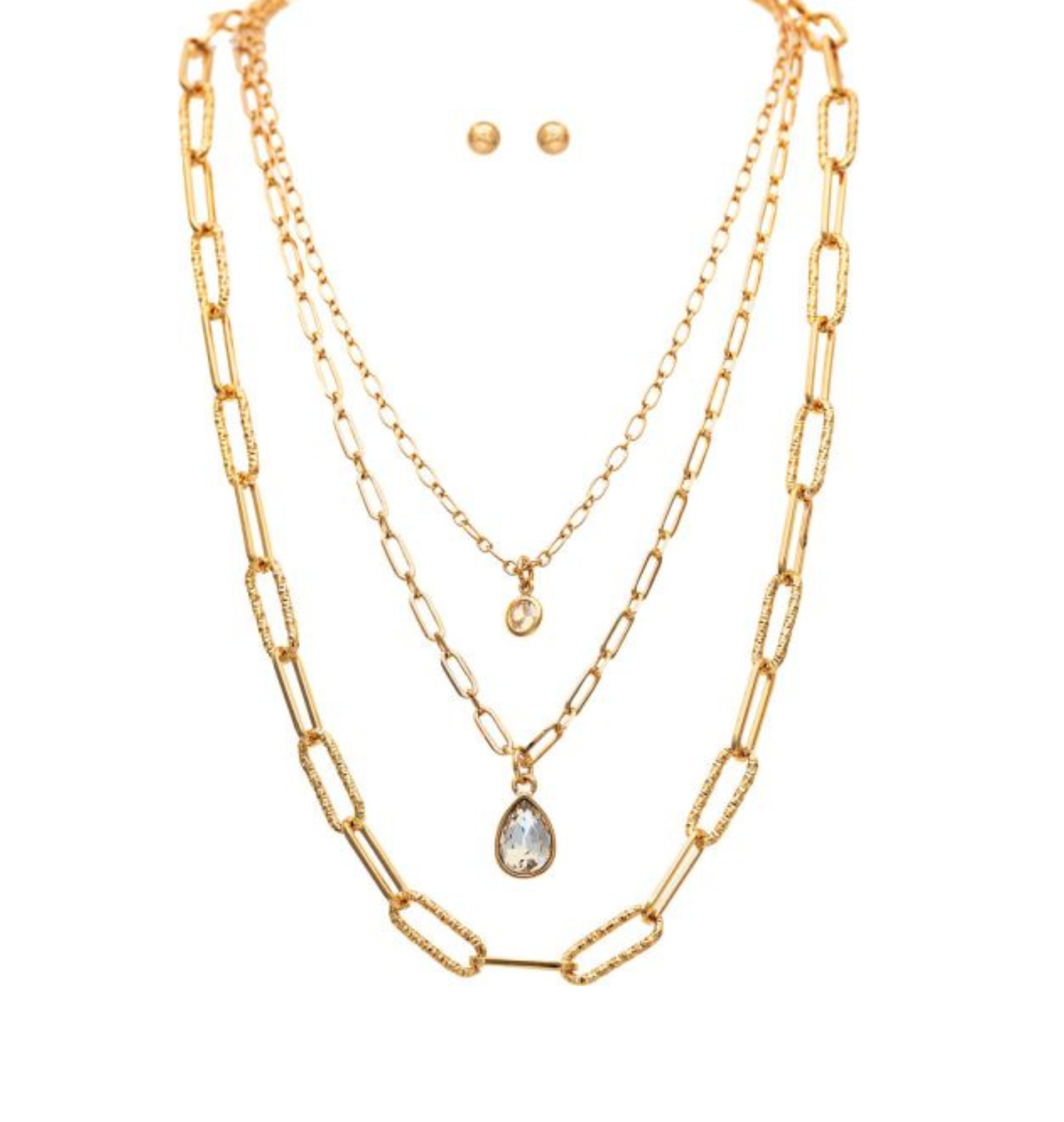 Displayed against a white background, the A-Train Gold Three Layered Chain Crystal Drops Necklace Set features three gold chain necklaces of varying lengths—each with a unique pendant, including a striking crystal drops design—paired with small gold stud earrings for an elegant layered look.