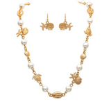 A-Train Gold Faux Pearl Beach Charms Necklace Set features gold sea-themed charms—including shells, turtles, and starfish—accented with shimmering faux pearls and beautifully showcased on a white background.