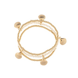 A-Train's Gold White Shell Beaded Stretch Bracelet features gold beads accented with small seashell charms and white, pearl-like beads, coiled in a circular arrangement on a white background. This elegant accessory perfectly captures the refined beauty of the Gold White Shell Beaded Stretch Bracelet, making it an ideal choice for adding sophistication to any outfit.