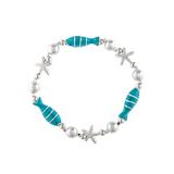 Introducing the A-Train Silver Faux Pearl Blue Enamel Fish Bracelet, a charming accessory featuring alternating silver faux pearls, silver starfish accents, and turquoise enamel fish-shaped beads arranged in a repeating pattern on a comfortable elastic band—an elegant piece perfect for enhancing any outfit.