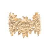 A gold ring adorned with three smiling sun faces and intricate detailing around the band perfectly complements the A-Train Gold Celestial Sun Moon Face Cuff Bracelet for a harmonious celestial-inspired look.