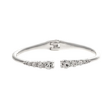 The Silver Crystal Ends Hinge Cuff Bracelet by A-Train features a row of round, clear gemstones on each open end that gradually increase in size toward the center; blending classic elegance with modern appeal, this refined piece is an ideal addition to any crystal hinge bracelet collection.