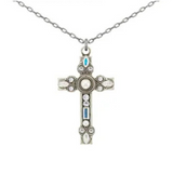 The Delicate Filigree White Pearl Cross Necklace by Firefly features an ornate cross pendant adorned with white and blue gemstones, elegantly displaying the beauty of handmade craftsmanship against a plain white background.