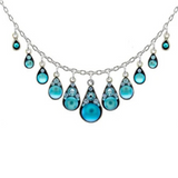 Experience the artistry of handmade jewelry with the Moonlight Waterfall Light Blue Necklace by Firefly. This stunning silver necklace features nine blue teardrop pendants, each adorned with delicate blue gemstones arranged in a graceful symmetrical pattern. Ethically crafted from fair trade materials, this exquisite piece is part of the Firefly Jewelry collection and makes an eye-catching statement accessory for any occasion.
